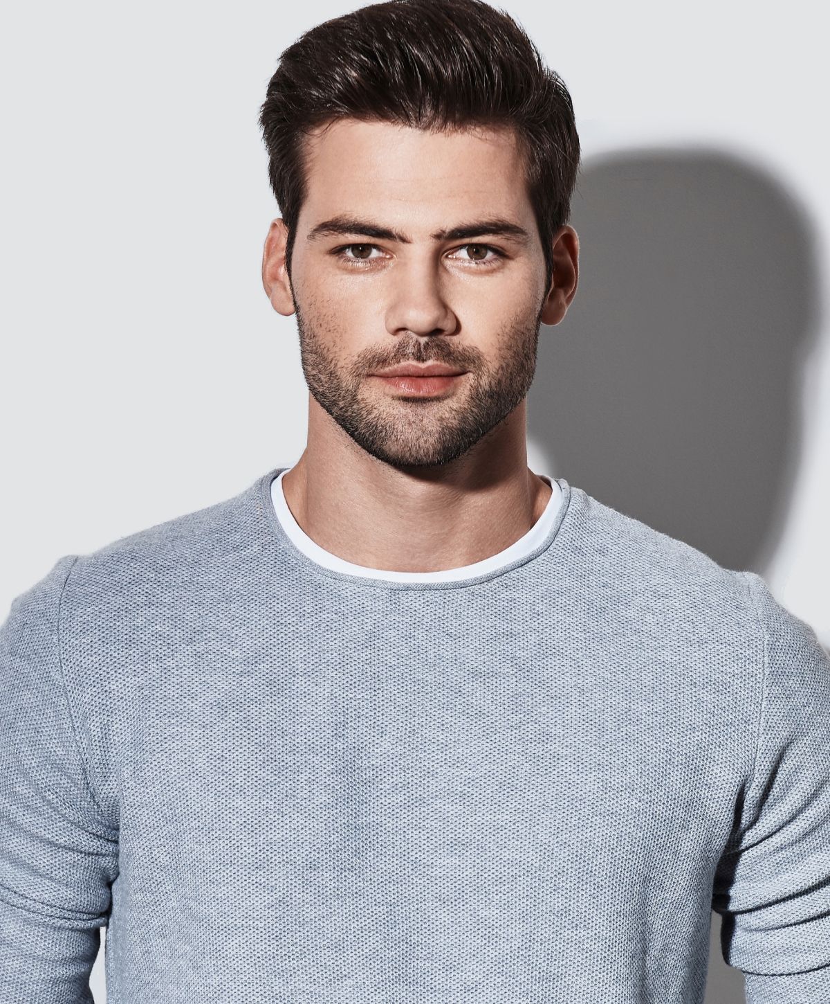 Man in sweater with neutral background.