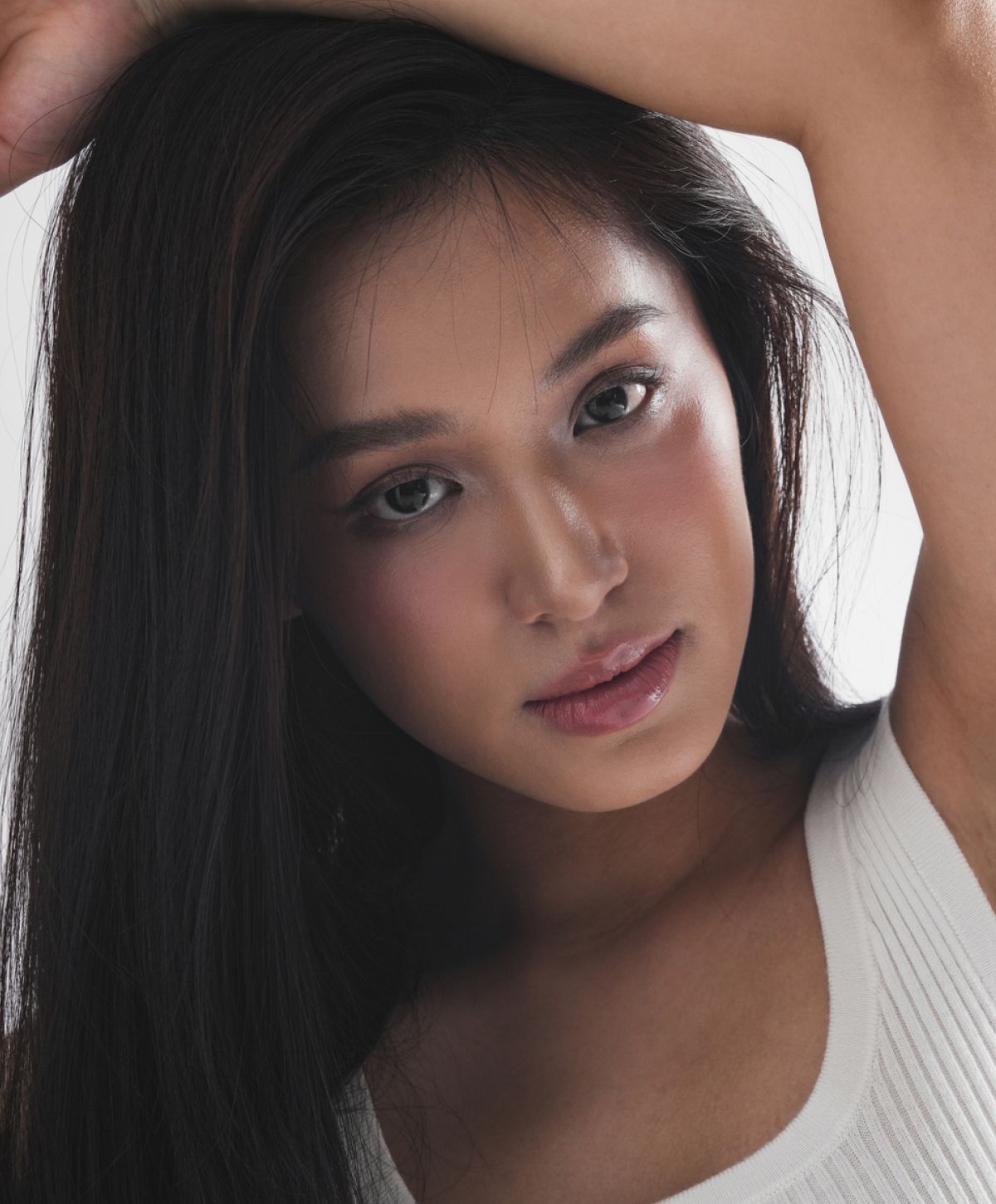 Young woman with long hair, posing thoughtfully.