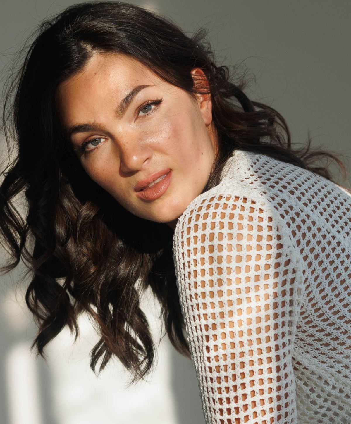 Woman with long hair in white sweater.