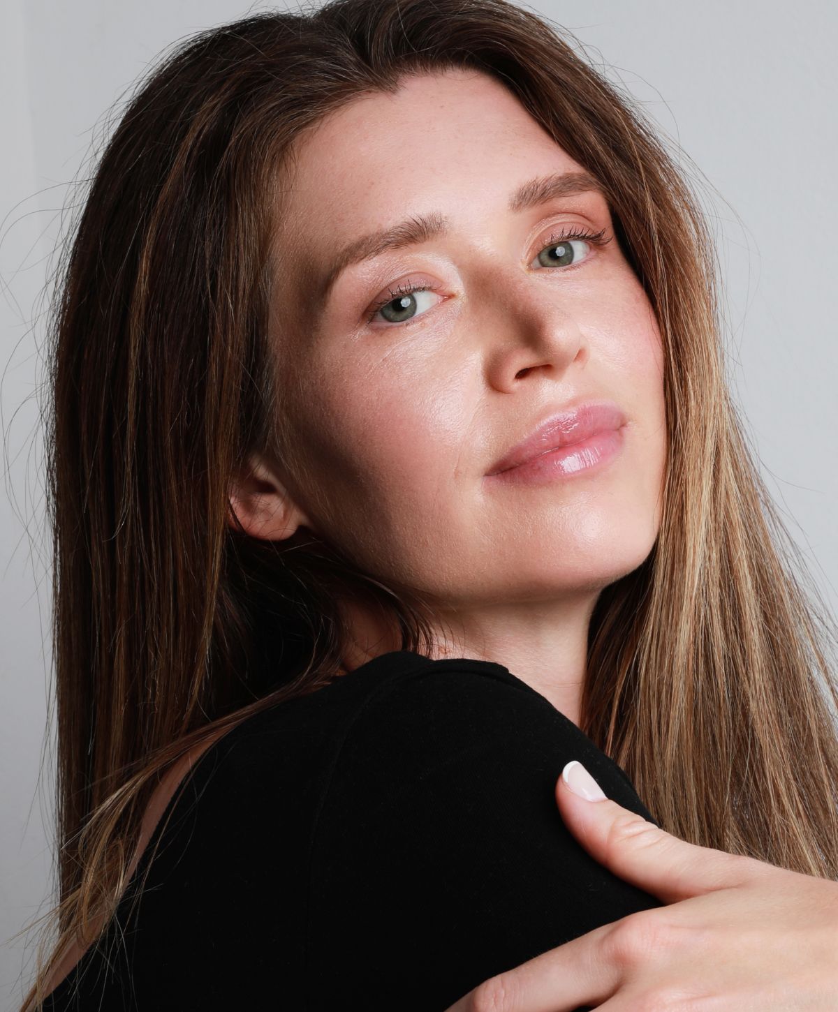 Woman with long hair smiling softly at camera.