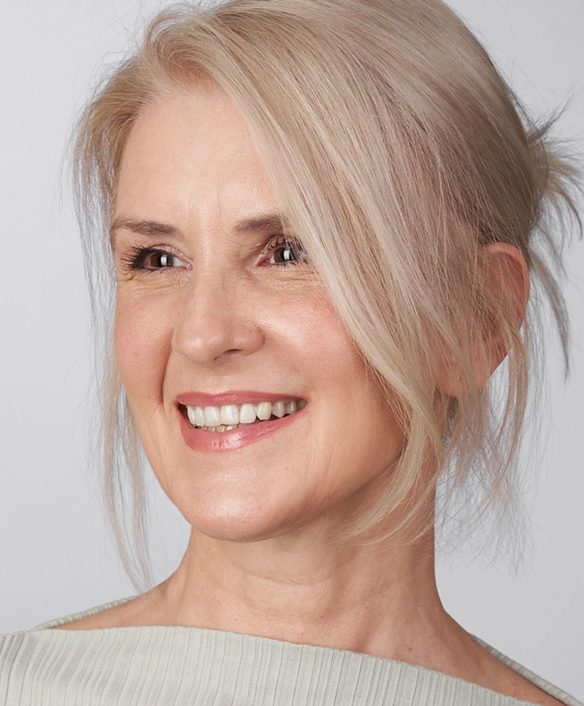 Smiling woman with blonde hair and light makeup.