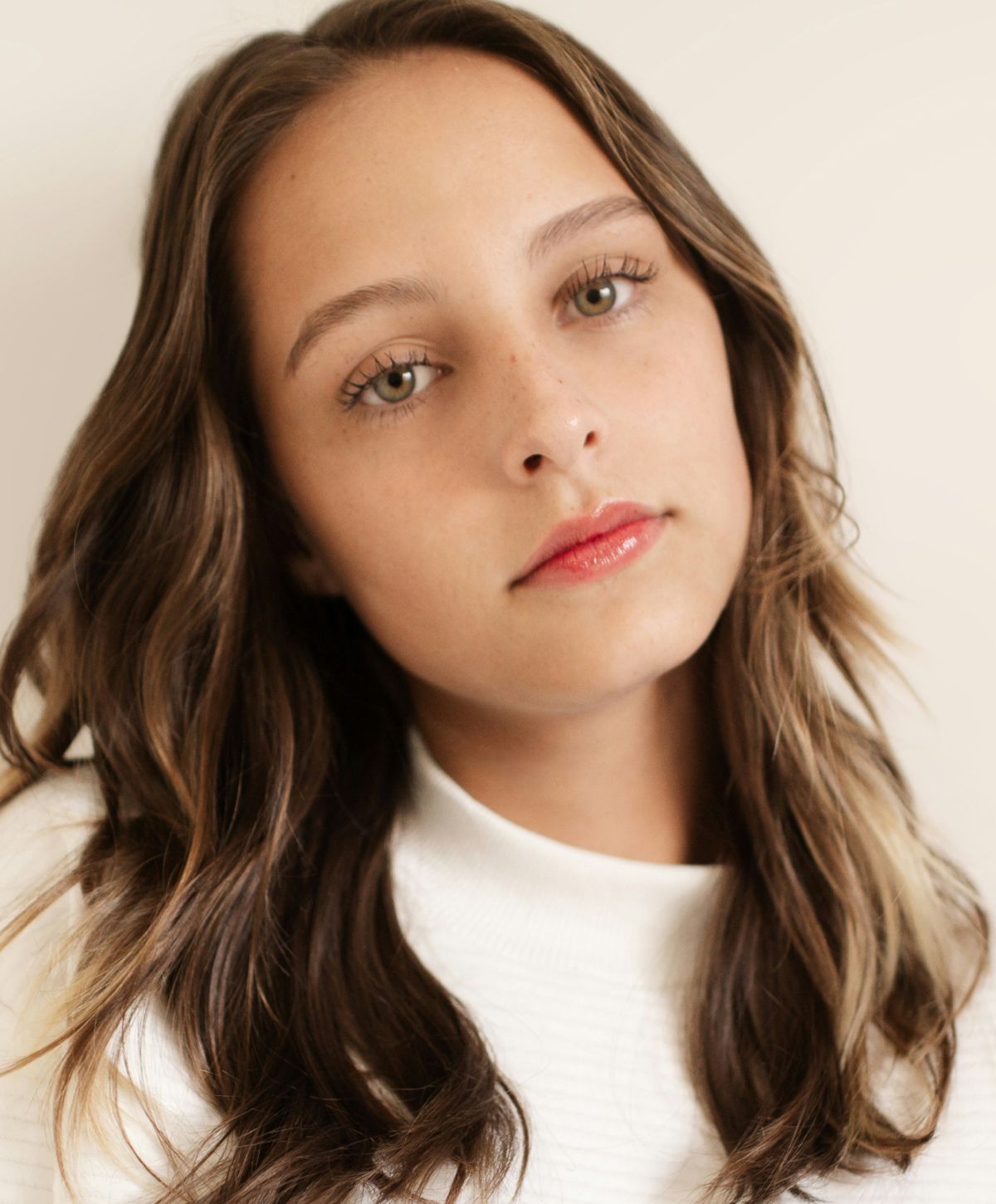Close-up portrait of young woman with wavy hair.