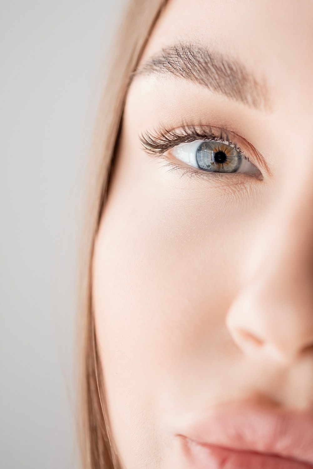 Smiling woman with beautiful eyelashes and glowing skin.