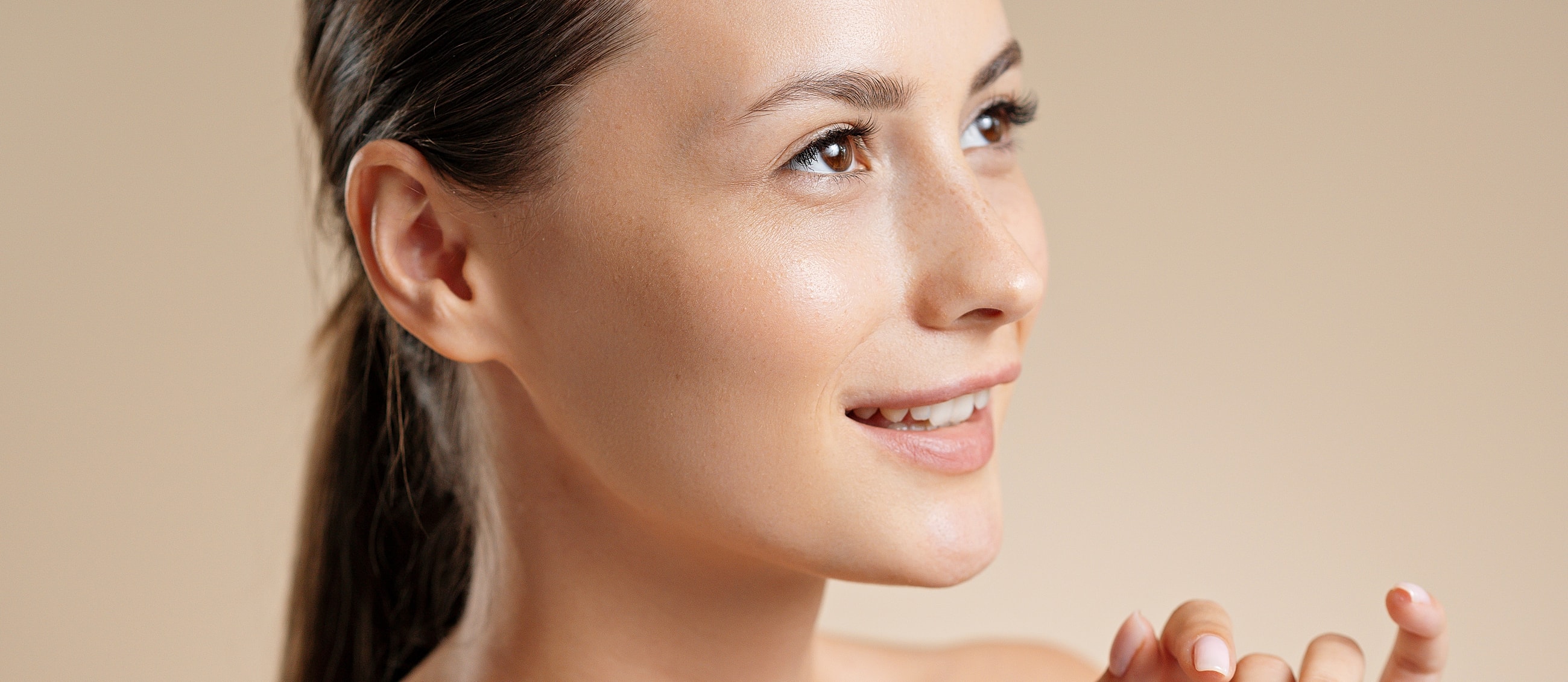 Smiling woman with beautiful eyelashes and soft lighting.