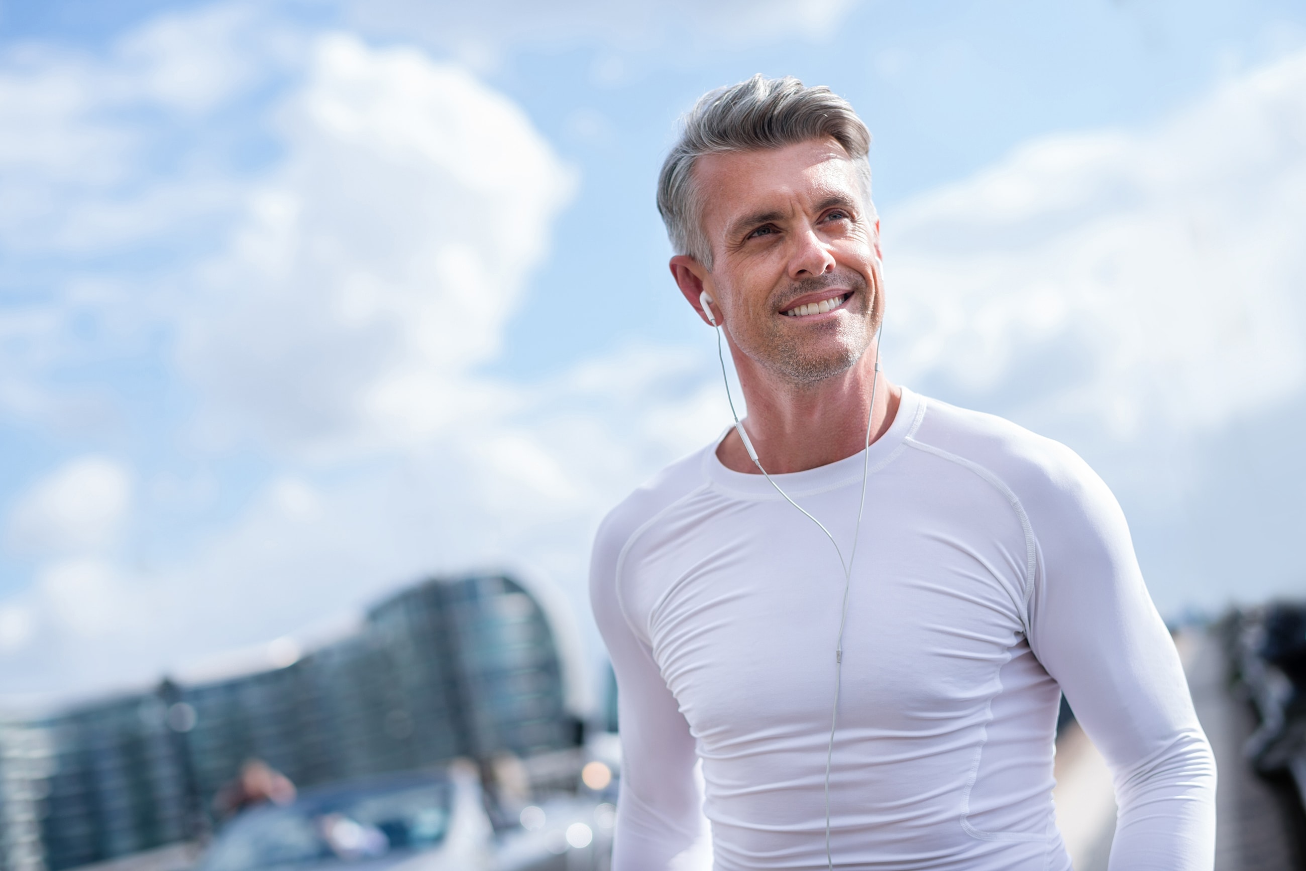 Man in white shirt against textured gray wall.