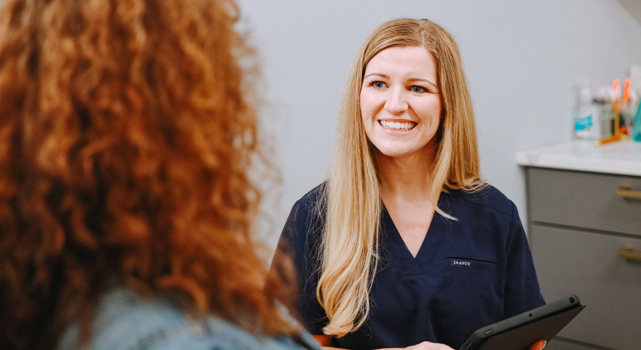 Smiling healthcare professional talking to a patient.